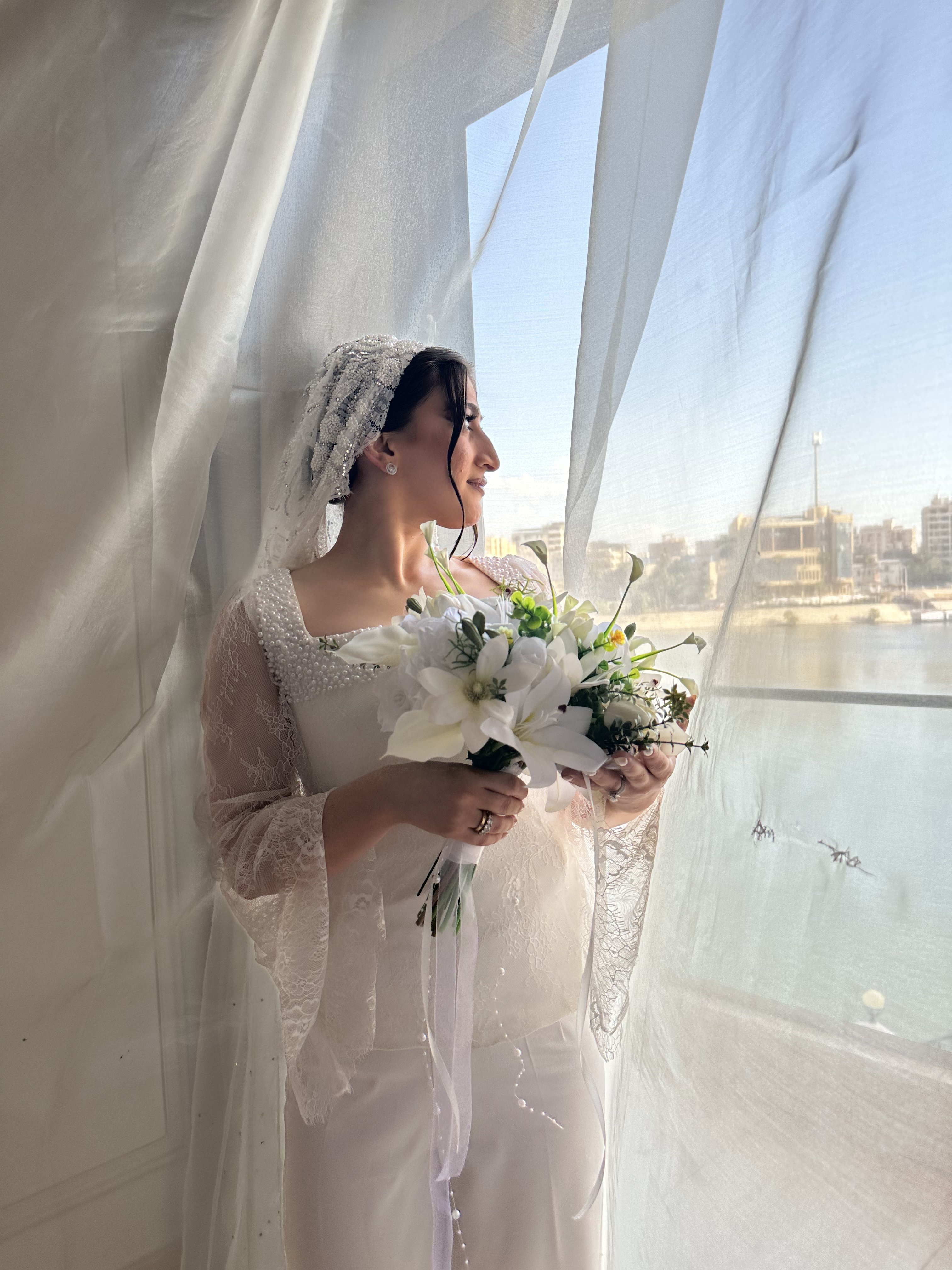 Bride by the window with bouquet